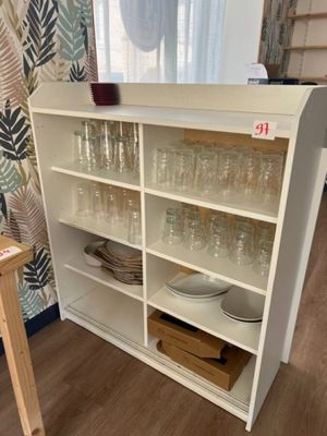 une étagère sur laquelle sont posés des verres et des assiettes, dans une pièce