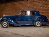 a blue car that is parked in front of a brick wall