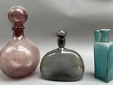 three glass bottles sitting next to each other on a table