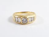 un gros plan sur une bague en or sertie d'un diamant et de diamants taille baguette