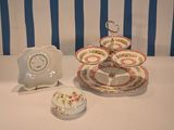 three plates and a clock on a table with blue and white striped wallpaper