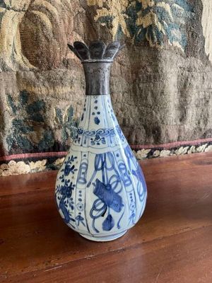 a blue and white vase sitting on a wooden table