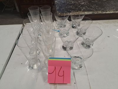 de nombreux verres à vin vides posés sur une table, sur laquelle se trouve un mot