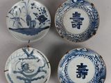quatre assiettes bleues et blanches ornées de motifs sur fond blanc