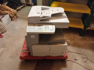 a printer sitting on top of a pallet in a room