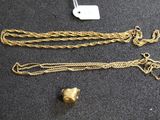 un gros plan sur un collier en or et une chaîne posés sur une table