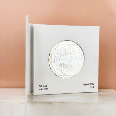 a white box with a silver coin on top of it