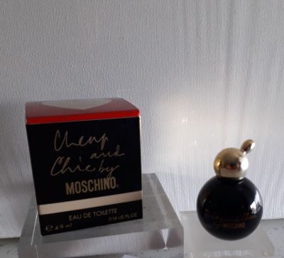 un flacon de parfum posé sur une table à côté d'une boîte de parfum