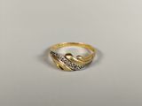 a close up of a gold and diamond ring on a white surface