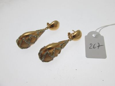 une paire de boucles d'oreilles dorées ornées de cristaux verts et d'une étiquette de prix