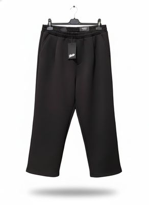 un pantalon noir suspendu à un cintre sur fond blanc