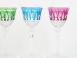 three wine glasses sitting next to each other on a white surface