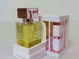 two bottles of perfume sitting next to each other on a table