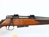 a rifle with a wooden barrel and a black muzzle on a white background