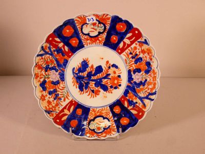 an orange and blue plate with flowers on it sitting on a table