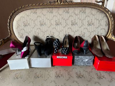 several pairs of women ' s shoes are lined up on a bed