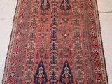an antique persian rug with a geometric design on a red ground