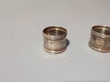 two silver rings sitting on a table next to each other