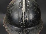 an old helmet is sitting on a stand on a black surface
