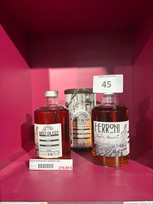 des bouteilles d'alcool sont posées sur une étagère dans une vitrine rose