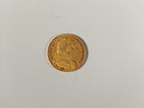 a close up of a gold coin on a white surface