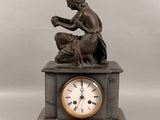 une statue de femme assise au sommet d'une horloge