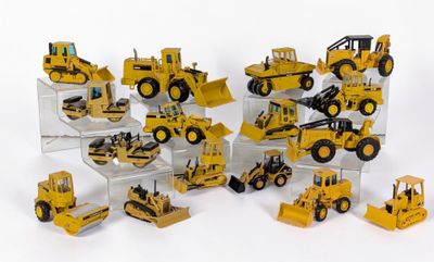 de nombreux engins de chantier miniatures exposés sur une surface blanche