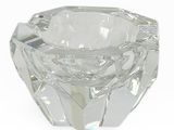 un bougeoir en verre transparent posé sur une surface blanche