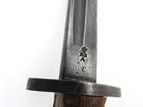 a close up of a knife with a wooden handle