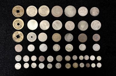 un grand nombre de pièces de monnaie qui se trouvent sur une surface noire