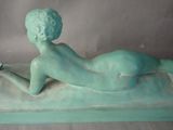a statue of a woman laying down on a table