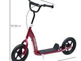 La trottinette est rouge et a une selle et des roues noires.