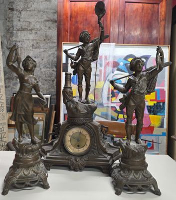 une statue en bronze représentant un homme et une femme, avec une horloge