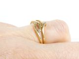 a person ' s hand holding a gold ring with a diamond