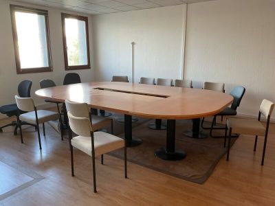une grande table entourée de chaises dans une pièce