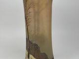a vase with a painting on it sitting on a table