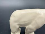a small white polar bear figurine on a black table