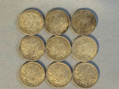 Six pièces britanniques sont disposées en rangée sur une table
