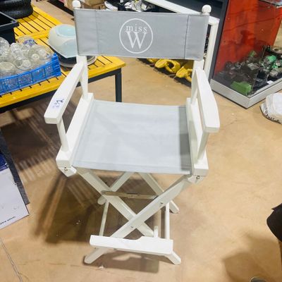 a white director ' s chair in the middle of a room
