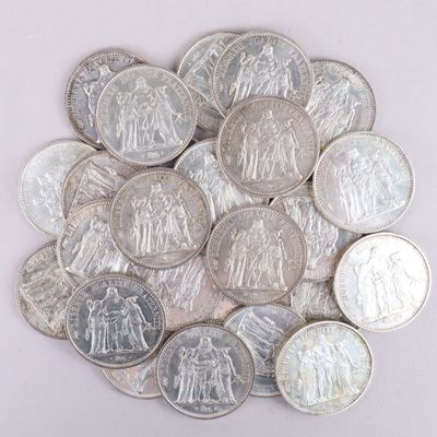 une pile de pièces d'argent posée sur une surface blanche