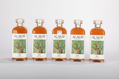 quatre bouteilles d'alcool posées les unes à côté des autres sur une surface blanche