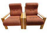 pair of orange upholstered lounge chairs with wooden arms