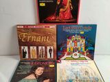 un lot de quatre CD posés sur une table blanche