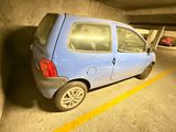 une petite voiture bleue garée dans un parking couvert