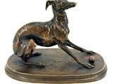 bronze statue of a greyhound dog on a base with a ball in its mouth