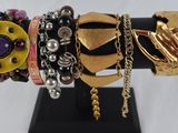 many different bracelets on display on a black stand