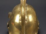 an antique brass helmet with a long neck and a long nose