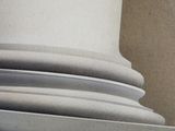 a bird sitting on top of a stack of white plates