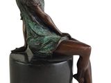 statue of a woman sitting on a stool with her legs crossed
