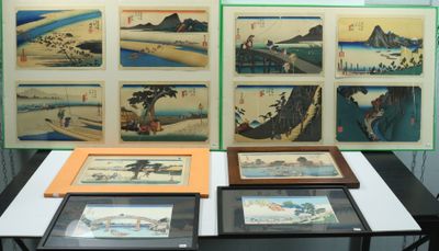 une table sur laquelle sont posées plusieurs œuvres d'art encadrées